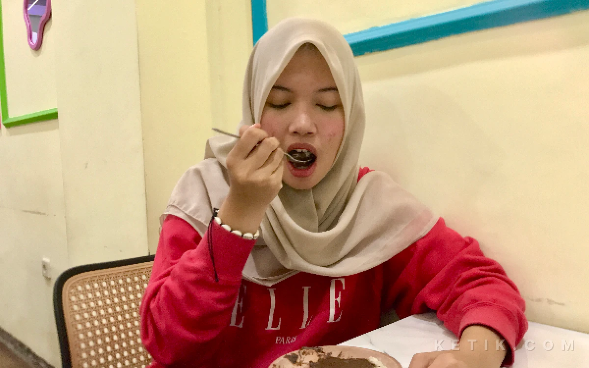 Foto Pelanggan Ketan Bersaudara, Sachiko sedang menikmati ketan putih dengan lelehan coklat di tempat duduk gerai pada Senin, 17 Agustus 2026 (Agitha Putri/ketik.com)