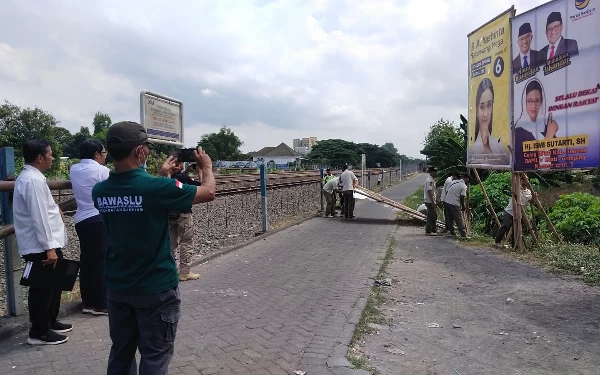 Tindak Lanjuti Laporan PT KAI, Bawaslu Sleman Bersihkan APK di Perlintasan KA