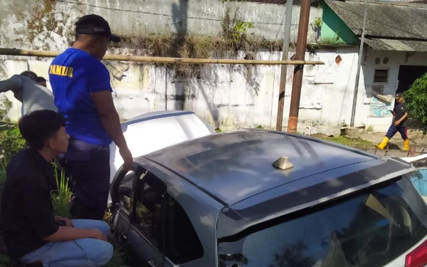 Mobil Angkutan Online Terperosok di Selokan Jalan Sempit, Damkar Jember Bantu Evakuasi