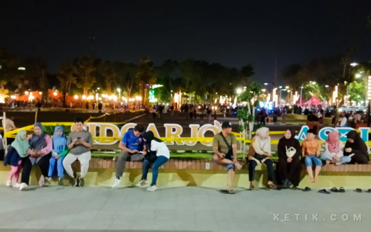Foto Pengunjung Alun-Alun Sidoarjo menyaksikan persiapan Nobar Final Piala Dunia Bareng Forkopimda Sidoarjo. Mereka menunggu untuk bergabung dengan ribuan warga lain. (Foto: Fathur Roziq/Ketik.com)