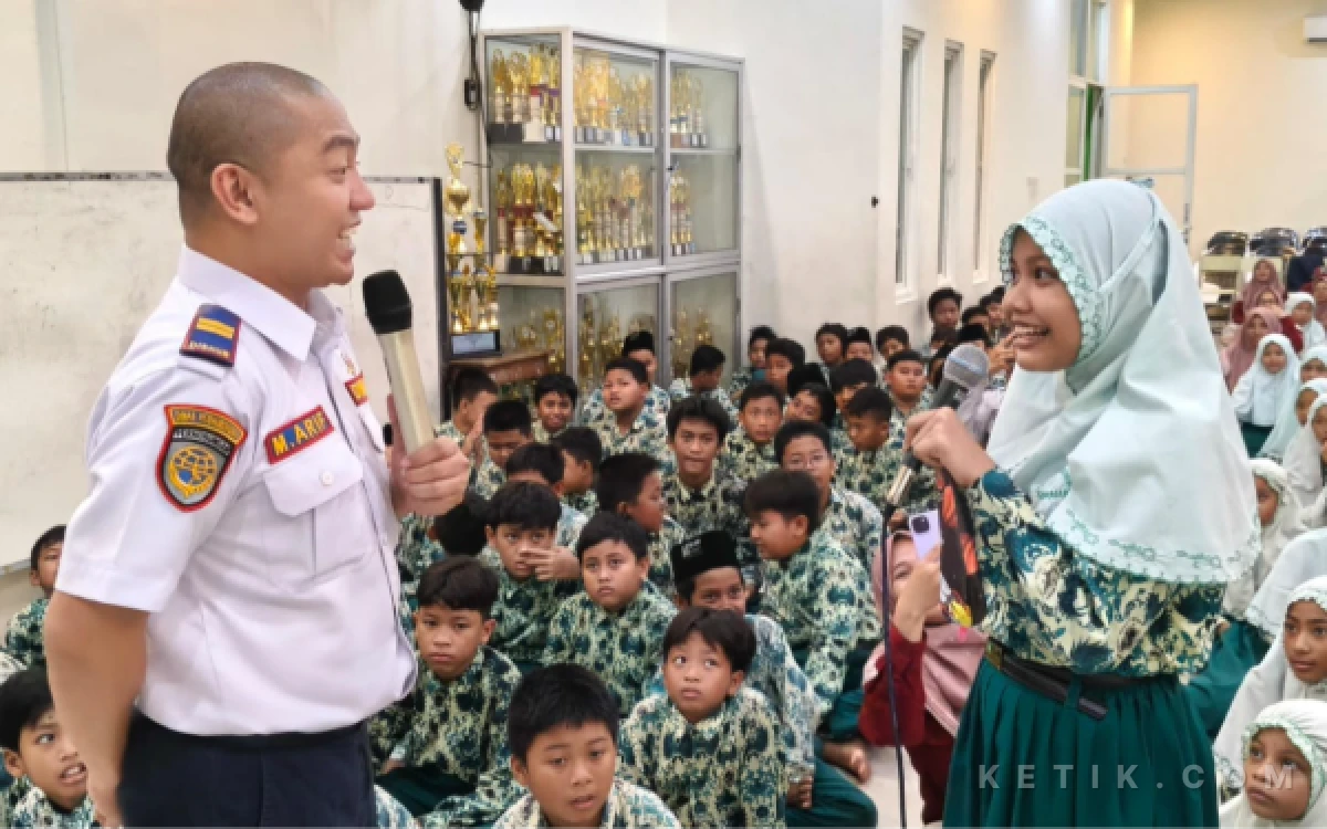 Foto Kepala UPT Pengelolaan Prasarana Perhubungan Wilayah Kota Dishub Gresik, Masyhur Arif, Berinteraksi Dengan Salah Satu Siswi MI Ma'arif Sidomukti (Foto: Daniel Andayawan/Ketik.com)