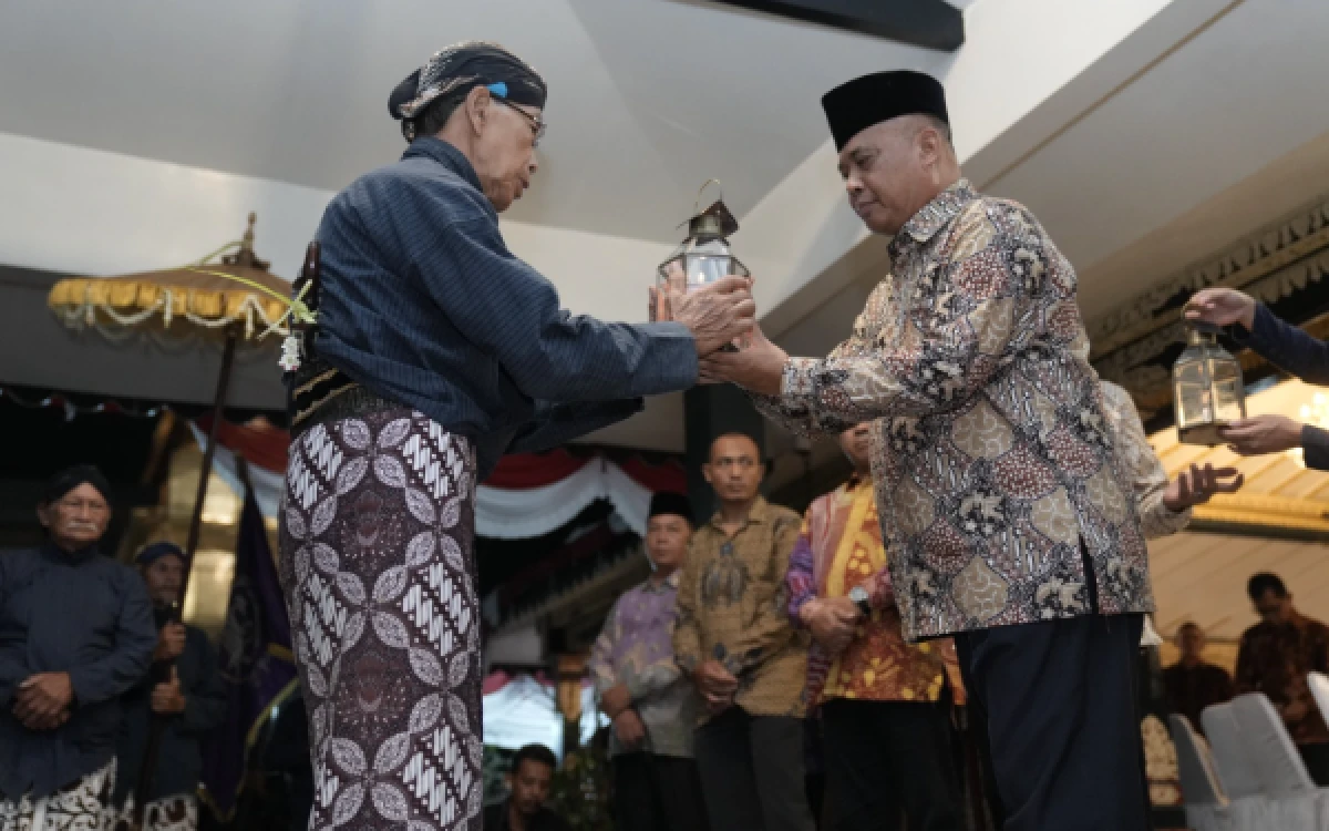 Foto Bupati Sleman Harda Kiswaya (kanan) menerima lentera saat prosesi ritual Malam Tirakatan Hari Jadi ke-110 Kabupaten Sleman di Pendopo Parasamya, Sleman, Yogyakarta, Kamis 14 Mei 2026. (Foto: Prokompim Slmn for Ketik.com)