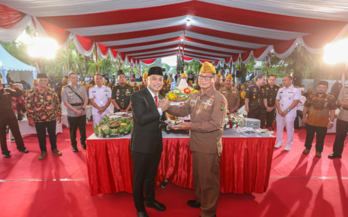 Foto Eri Cahyadi Walikota Surabaya menyerahkan potongan tumpeng ke Gitoyo ketua LVRI kota Surabaya. (Foto : Infokom for ketik.com)