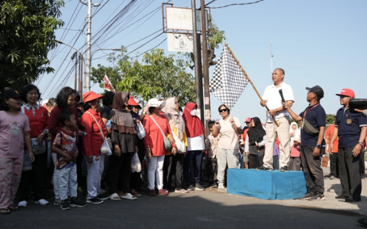 Foto Bupati Sleman Harda Kiswaya mengibarkan bendera start saat melepas peserta jalan sehat warga Perumnas Condongcatur di Depok, Sleman. Kegiatan ini menjadi bagian dari rangkaian peresmian Ruang Terbuka Hijau (RTH) setempat untuk menggalakkan pola hidup sehat dan kebersamaan warga. (Foto: Fajar R/Ketik.com)