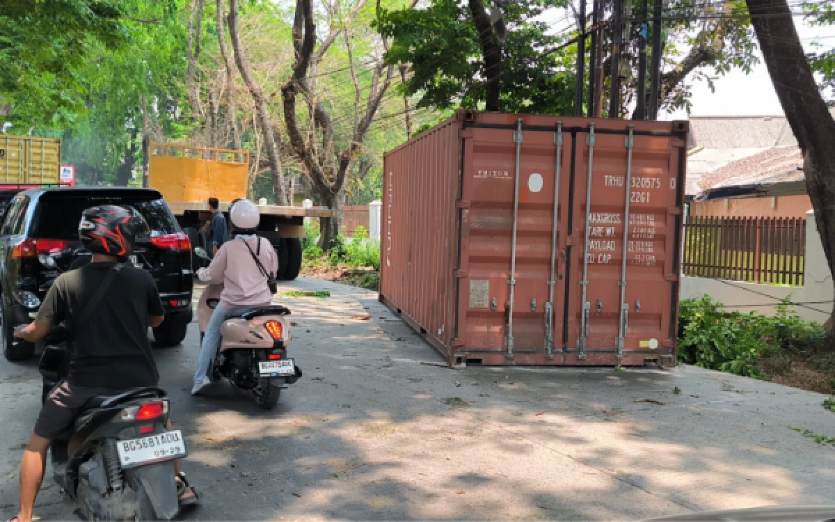 Thumbnail Berita - Nekat Lewat Jalan Kota, Truk Kontainer di Sako Tersangkut Dahan hingga Kontainer Jatuh