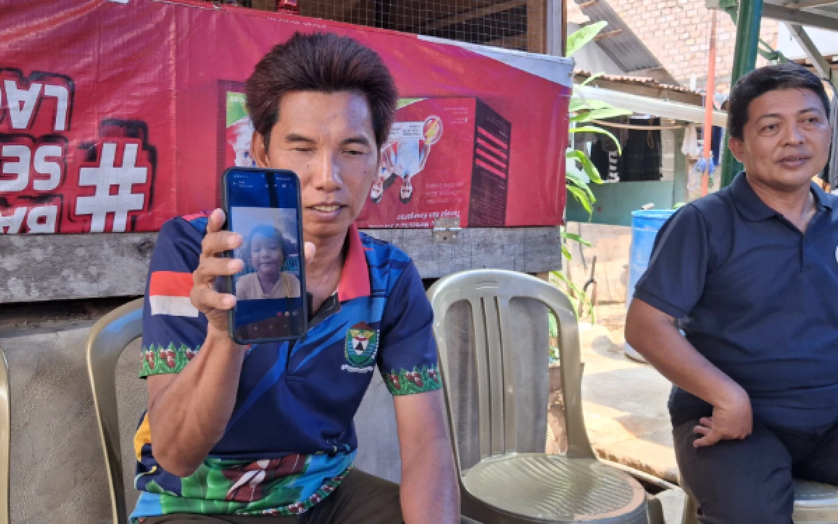 Foto Ayah salah satu korban tenggelam di IPAL Pasar Ikan modern, Iwan Susanto saat menunjukkan foto anaknya, Kamis 20 Agustus 2026. (Foto : Yola/Ketik.com)