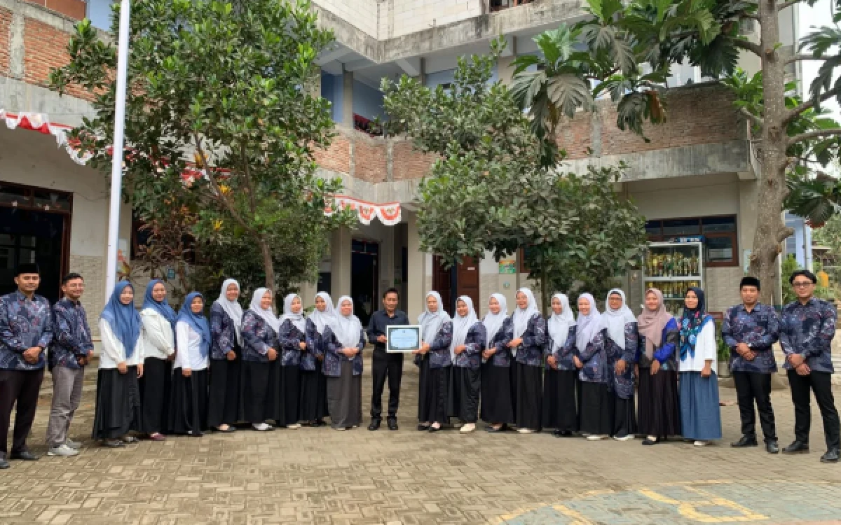 Foto Penyerahan piagam kepada Dr. Mohamad Zubad Nurul Yaqin, M.Pd., pakar pendidikan dari UIN Maulana Malik Ibrahim Malang dari guru dan tendik MI Cemorokandang Kota Malang. (Foto: Dok. Pribadi)
