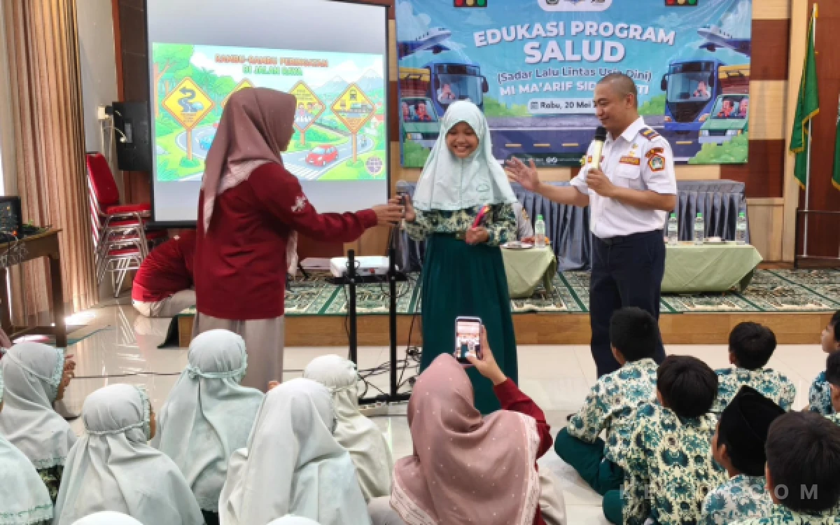 Foto Siswi MI Ma'arif Sidomukti Gresik Mendapatkan Hadiah Dari Petugas Dishub Gresik Setelah Menjawab Pertanyaan Mengenai Kesadaran Berlalu Lintas (Foto: Daniel Andayawan/Ketik.com)