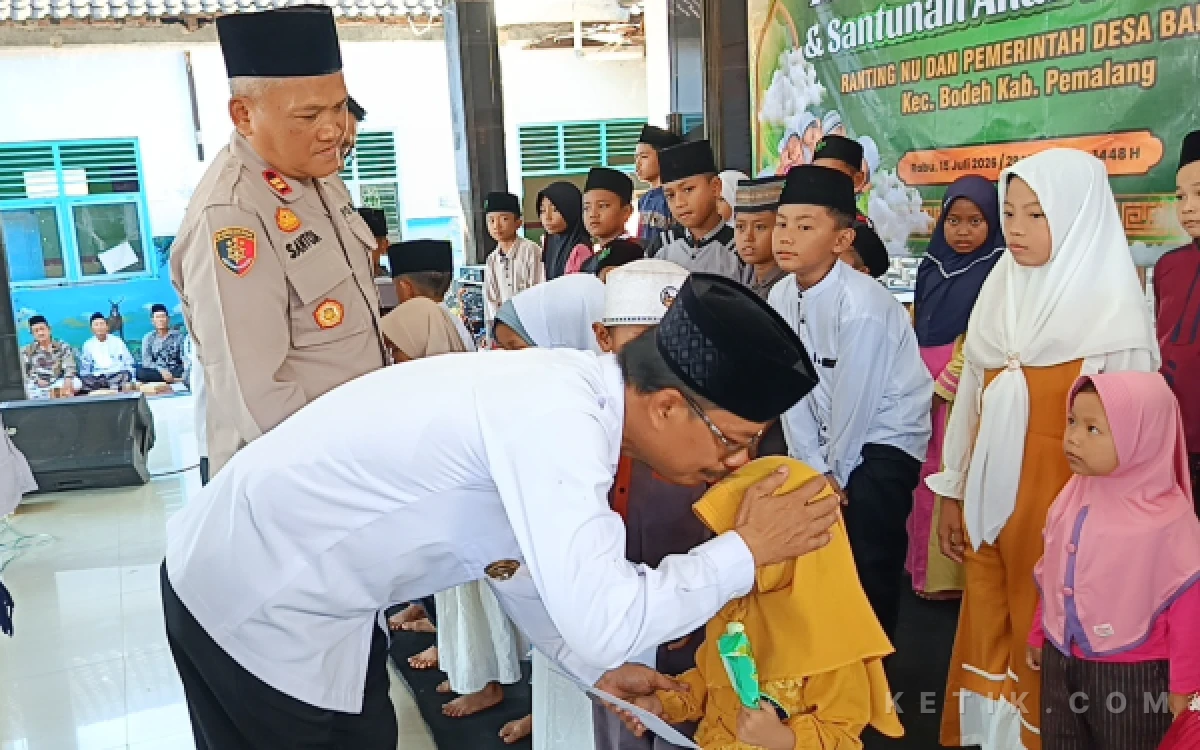 Foto Kepala Desa Babakan, Kustoni BR mencium anak yatim saat menyerahkan santunan (Foto: Slam/ketik.com)