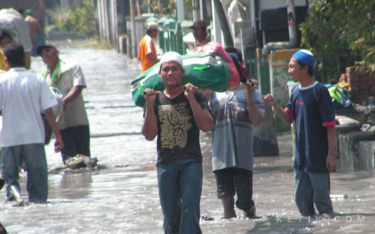 Foto Warga Kelurahan Siring berhamburan keluar kampung setelah mendengar tanggul lumpur jebol pada Kamis pagi (10 Agustus 2006). (Foto: Dokumen Fathur Roziq)