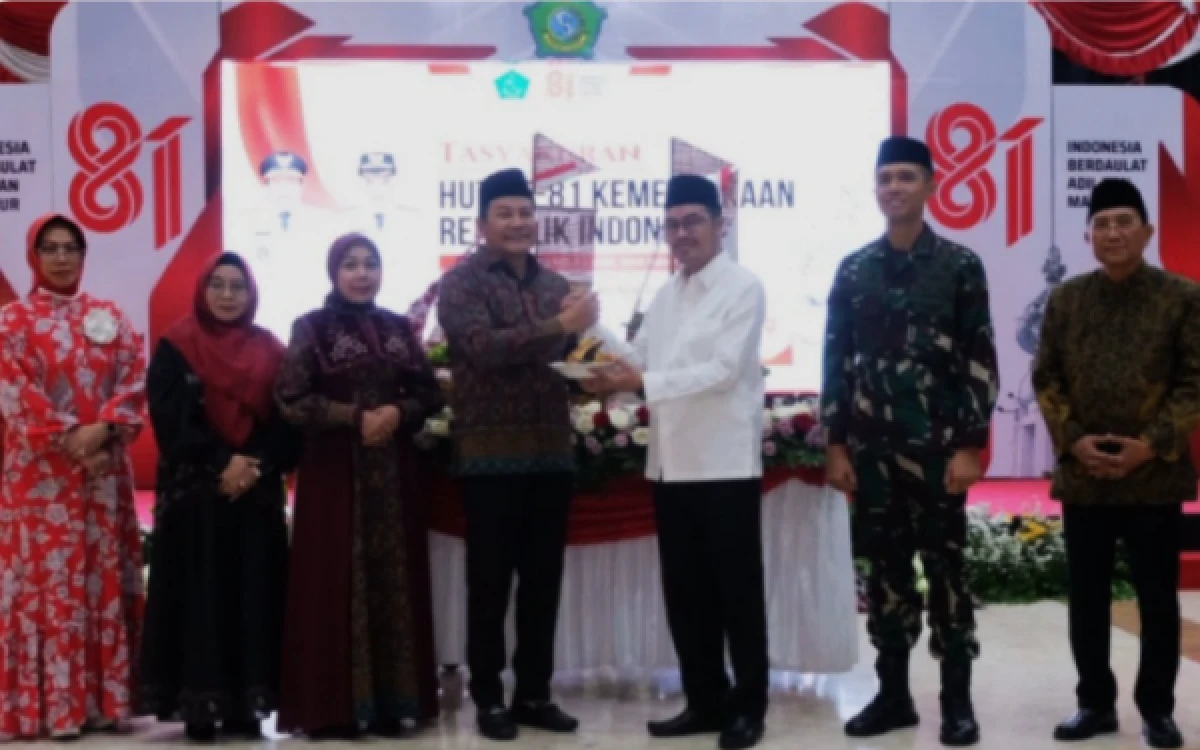 Foto Bupati Subandi menyerahkan potongan tumpeng kepada Ketua DPRD Sidoarjo Abdillah Nasih pada malam Tirakatan Peringatan HUT Ke-81 Kemerdekaan RI. (Foto: Dokumen)