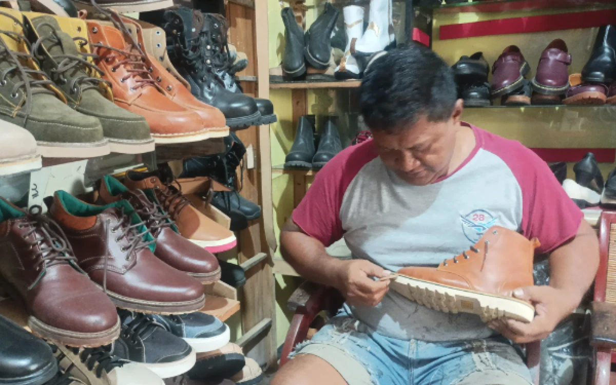 Foto Pemilik Sello Shoe, Tius Darmawanto saat mengelem dan menyemir sepatu kulit kustom buatannya, Rabu, 3 Juni 2026 (Foto : Kukuh / Ketik.com)