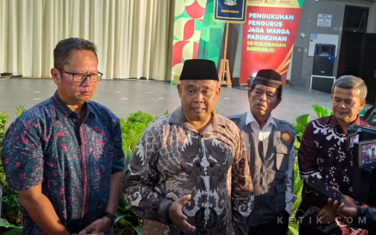 Foto Bupati Sleman Harda Kiswaya didampingi Kasat Pol PP Sleman Indra Darmawan (paling kiri) dan Lurah Sarbini (pakai rompi) memberikan keterangan usai mengukuhkan Pengurus Kelompok Jaga Warga se-Kalurahan Sariharjo. (Foto: Fajar R/Ketik.com)