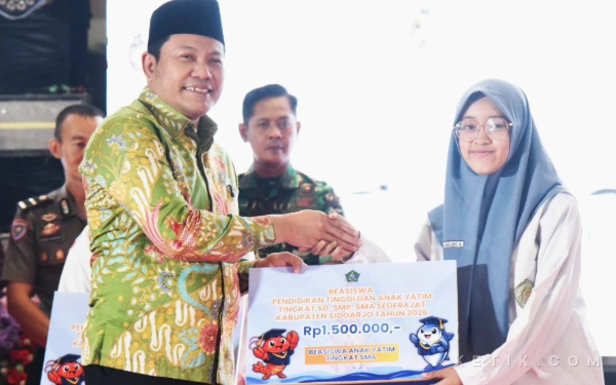 Foto Penerima beasiswa untuk anak yatim jenjang SMA tersenyum saat menerima penyerahan beasiswa dari Bupati Subandi. (Foto: Fathur Roziq/Ketik.com)