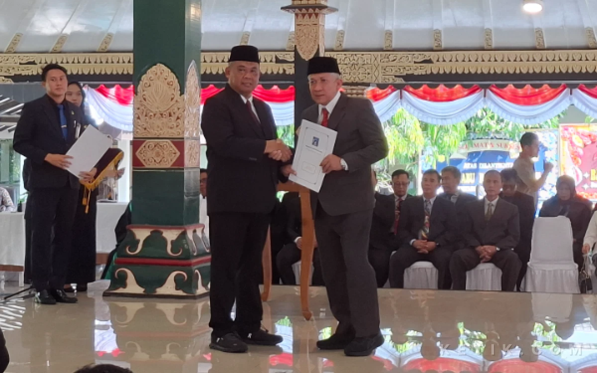 Foto Bupati Sleman Harda Kiswaya (kiri), melakukan jabat tangan dengan Abu Bakar, Sekda Sleman yang baru saja dilantik seusai penandatanganan berita acara dan penyerahan surat keputusan jabatan. (Foto: Fajar R/Ketik.com)