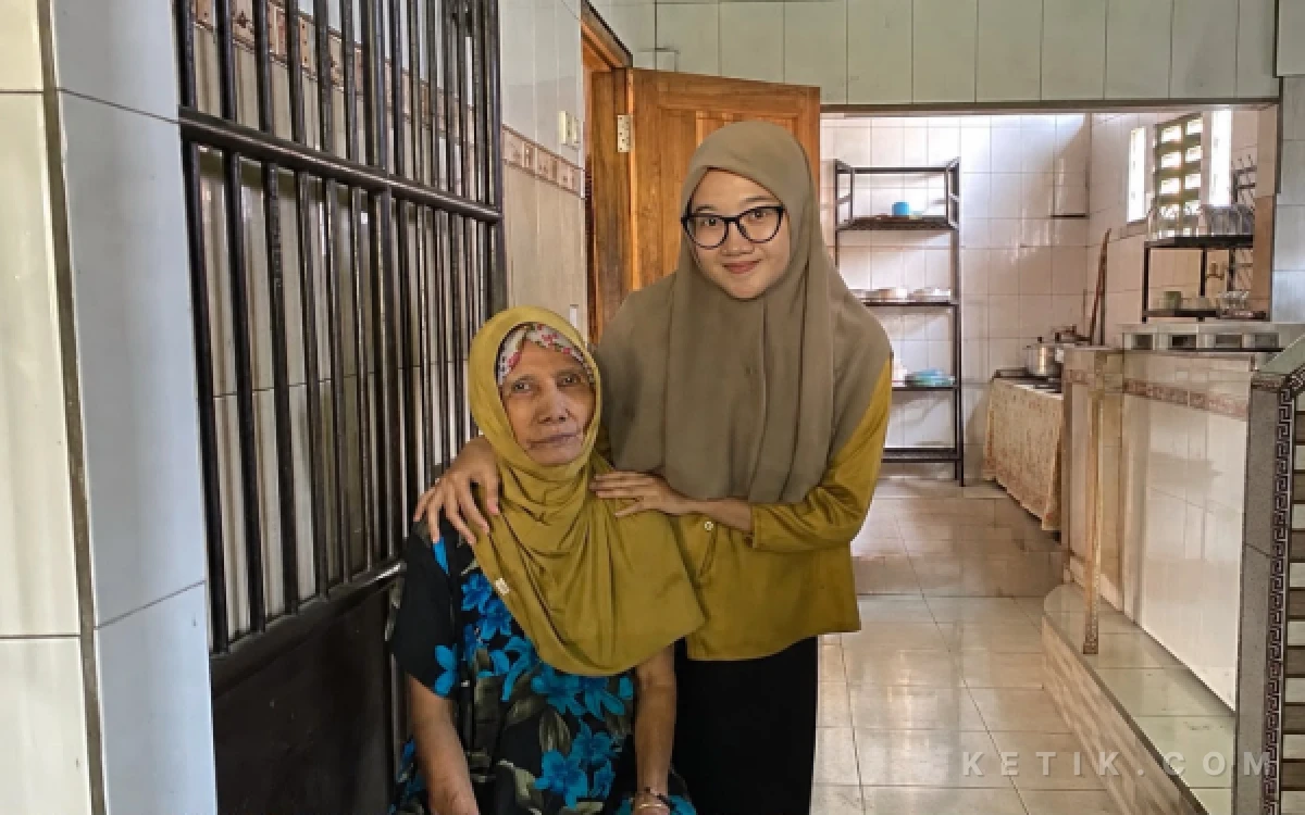 Foto Potret Hj. Simpen bersama cucunya di area dapur Rujak Cingur Hj. Simpen, Sukodono, Sidoarjo. Usaha kuliner yang dirintis Hj. Simpen sejak 1971 tersebut kini telah diteruskan hingga generasi kedua.