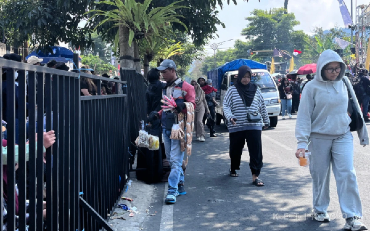 Foto Surahno menawarkan dagangannya kepada pengunjung Festival Bantengan Nuswantara di area finish Balai Kota Batu, Minggu, 02 Agustus 2026. (Foto: Faiz/Ketik.com)