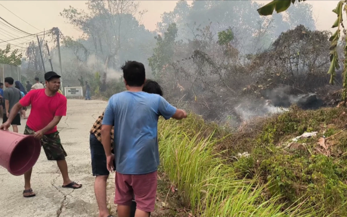 Foto Warga sekitar yang mencoba memadamkan api di lahan terbakar di Jalan Lebung Permai, Kelurahan Talang Kelapa, Kecamatan Alang-Alang Lebar, Palembang, Selasa 29 September 2026. (Foto : Yola/Ketik.com)