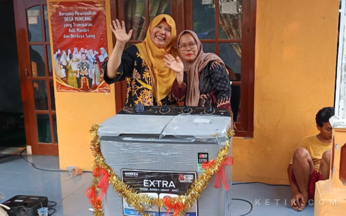 Foto Pemenang undian hadiah doorprize mesin cuci foto bersama Istri bakal calon kepala Desa Muncang, Daryoto (Foto: Slam/ketik.com)