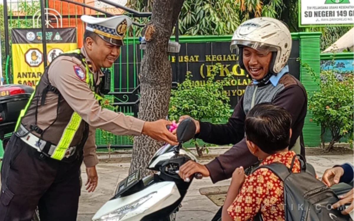 Thumbnail Berita - Unit Lantas Polsek Driyorejo Gresik Bagi-Bagi Kue untuk Orang Tua Tertib Gunakan Helm Antar Anak Sekolah