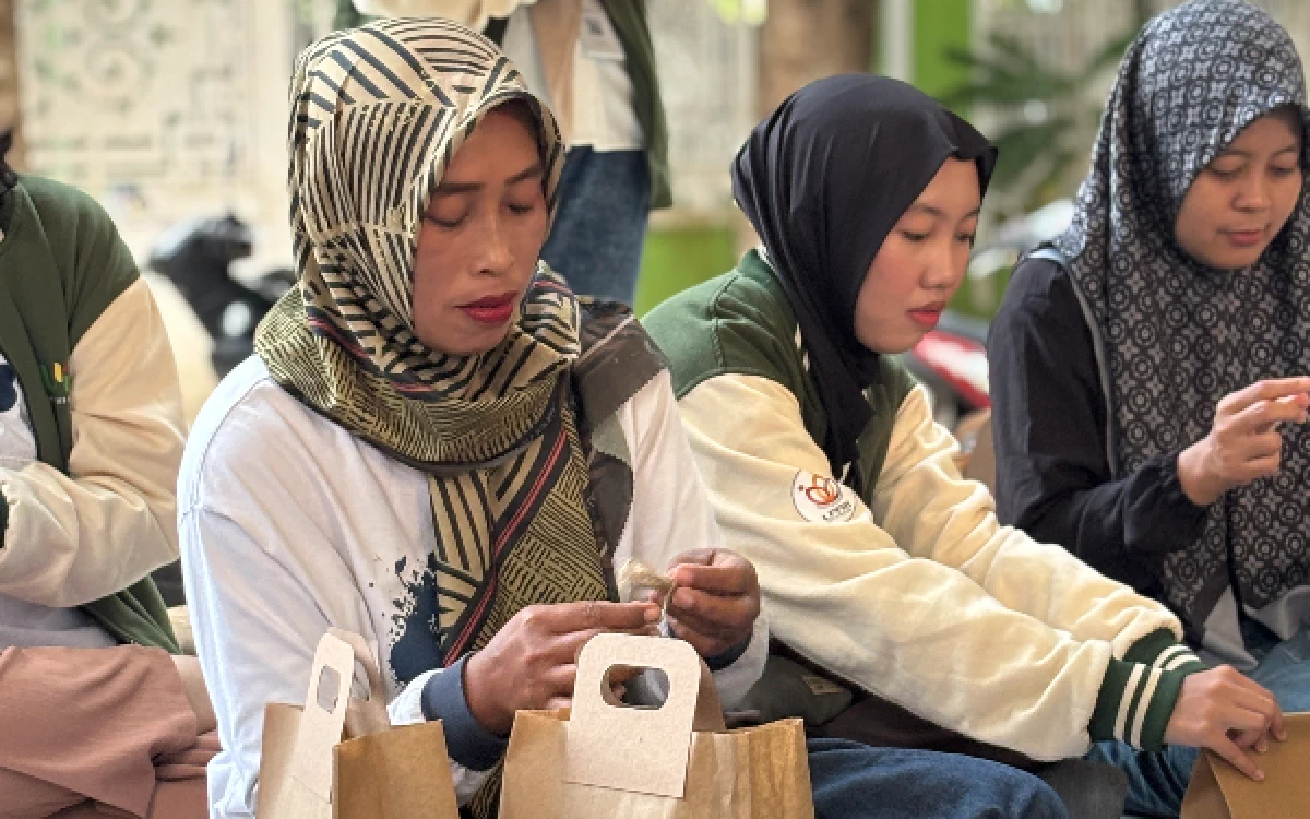 Foto Suasana praktik pengemasan briket bonggol jagung secara mandiri oleh kader PKK Desa Wringinpitu. (Foto: Dok. KKN Kelompok 19 UPN Jatim)