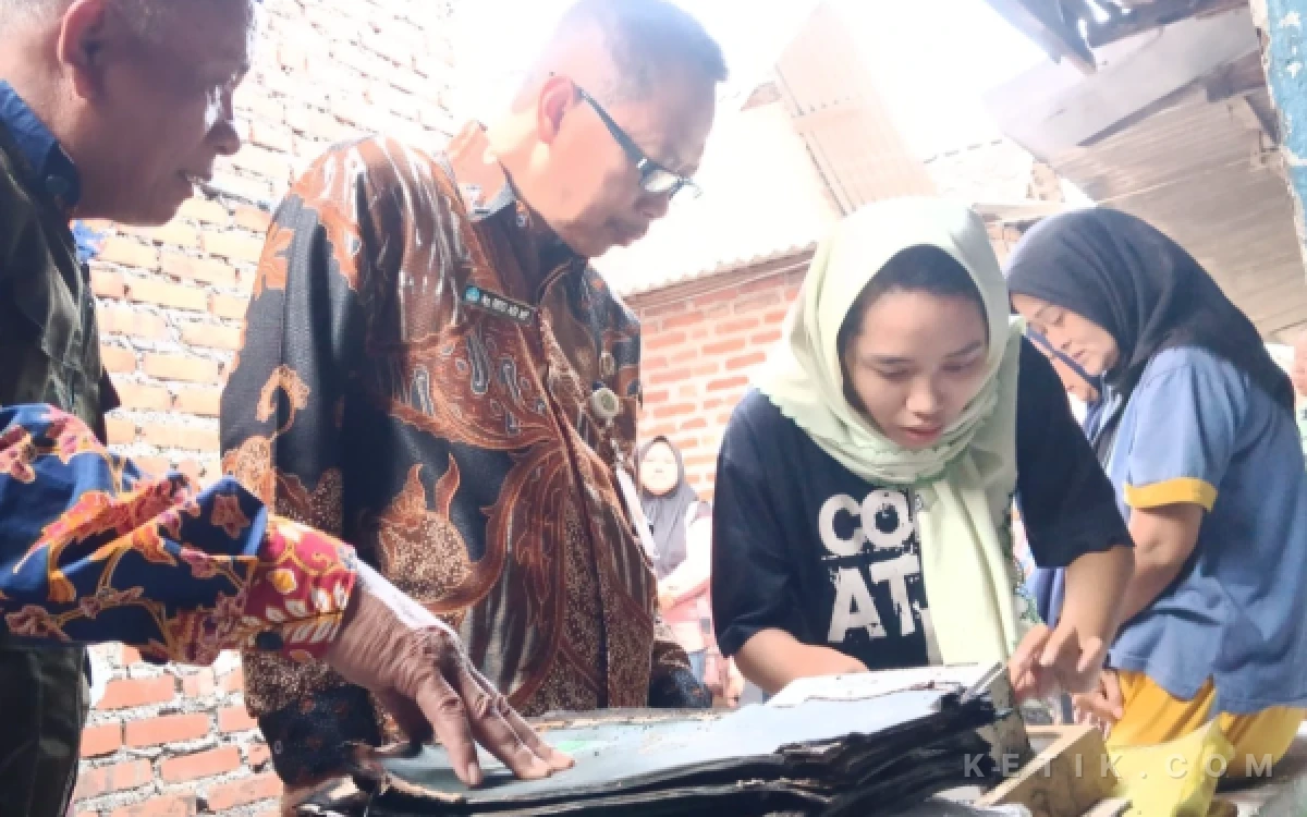 Foto Kepala Disdikbud Sidoarjo Tirto Adi dan Anita Dwi Setiawati melihat berkas ijazah, rapor, dan transkrip nilai kuliah yang terbakar. (Foto: Fathur Roziq/Ketik.com)