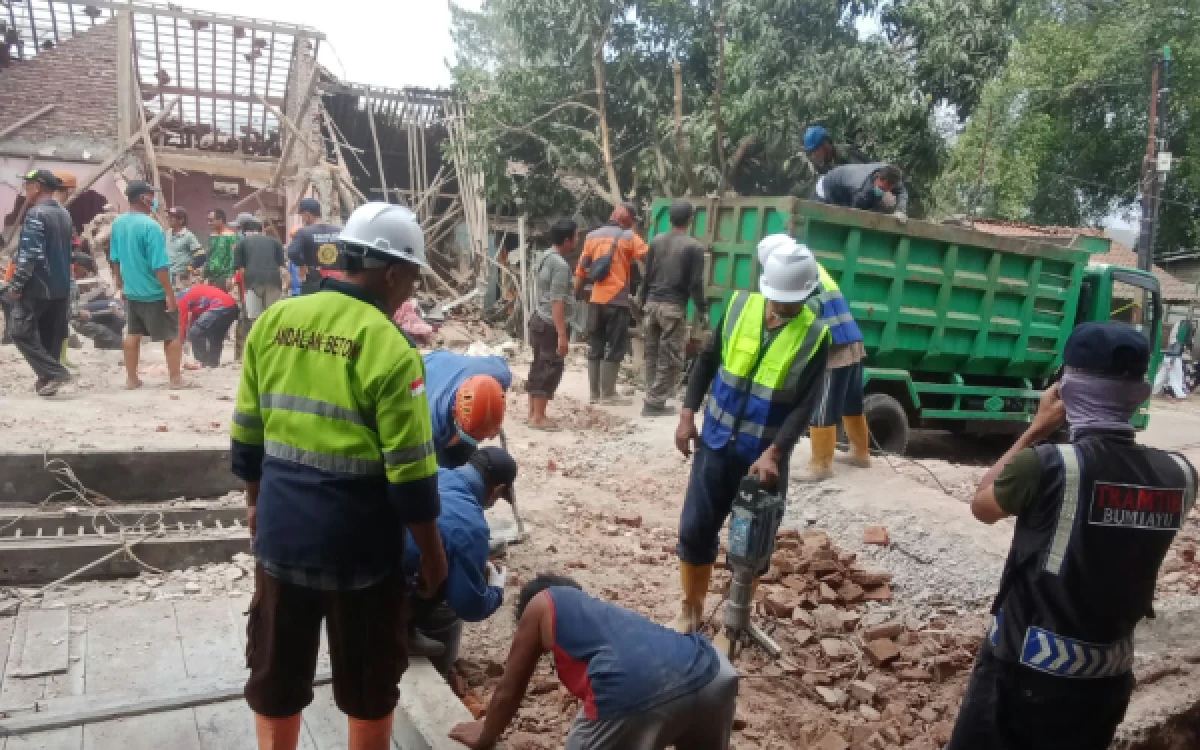 Foto Relawan membereskan puing reruntuhan