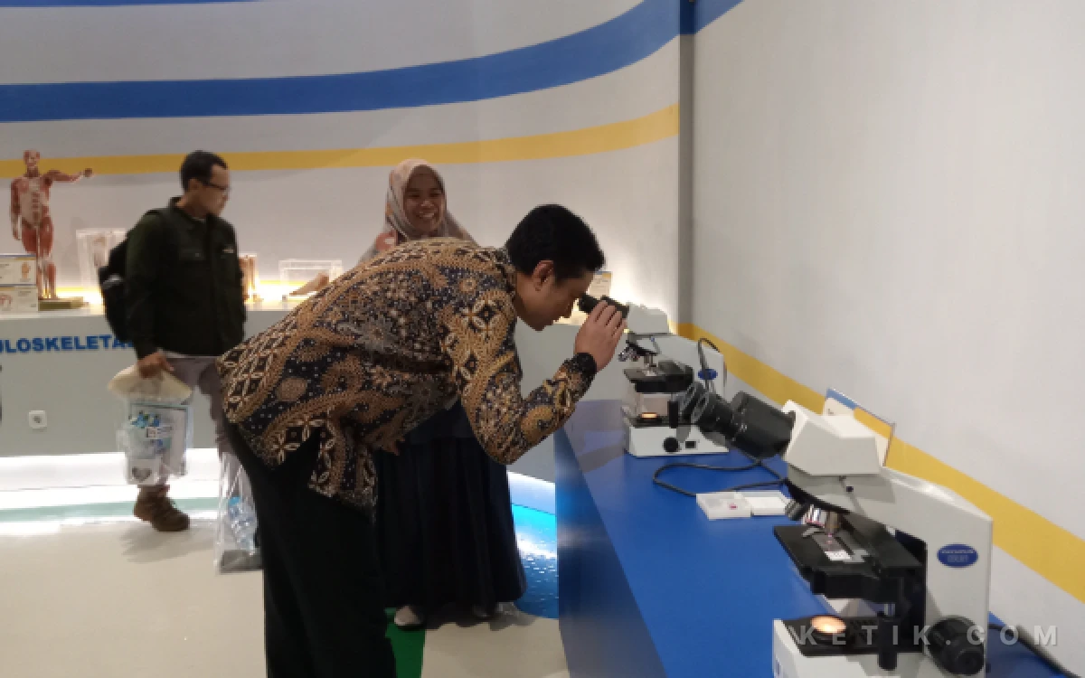 Foto Wakil Rektor 4 UB, Andi Kurniawan, S.Pi., M.Eng., D.Sc., mencoba alat mikroskop di Museum Anatomi FK UB. (Foto: Aliyah/Ketik.com)