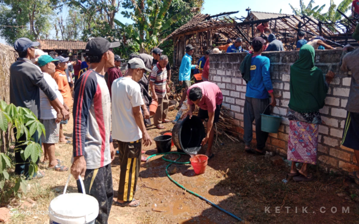 Foto Secara swadaya, warga bergotong-royong mengangkut dan mengalirkan air menggunakan ember untuk memadamkan kobaran api yang menghanguskan kandang ternak di Desa Pantenan, Panceng, Gresik, Minggu (9/8/2026). (Foto: Aris/Ketik.com)