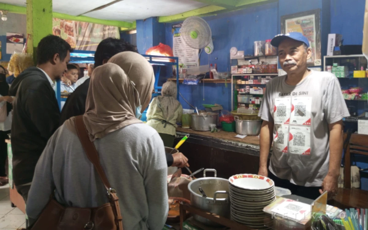 Foto Pemilik Warung Isor Nongko, Hari (Kanan), melayani pelanggan di warungnya. (Foto: Alifia/Ketik.com)