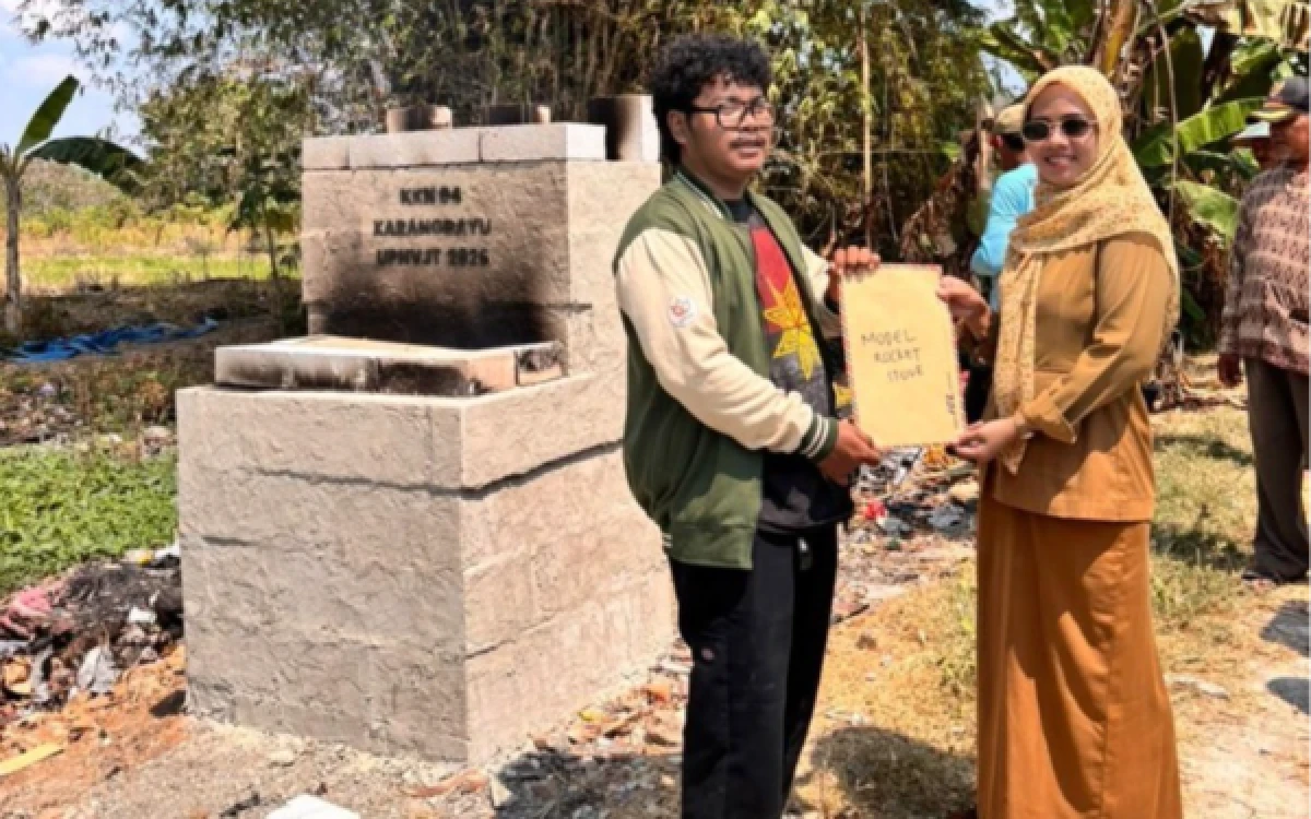 Foto Penyerahan secara simbolis dokumen panduan penggunaan Model Rocket Stove oleh perwakilan mahasiswa KKN Kelompok 04 UPN “Veteran” Jawa Timur kepada Sekretaris Desa Karangdayu, di depan bangunan Alat Pembakaran Sampah Minim Asap di Desa Karangdayu, Kecamatan Baureno, Kabupaten Bojonegoro, Senin (10/8/2026). (Foto: Dok. KKN Kelompok 04 Bojonegoro UPN "Veteran" Jawa Timur)