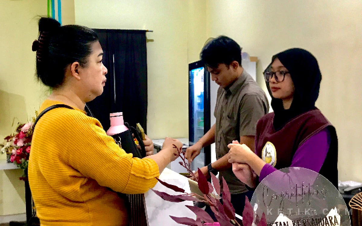 Foto Seorang karyawan, Kayana sedang menjelaskan pilihan menu ke pembeli Ketan Bersaudara di kasir pada Senin, 17 Agustus 2026 (Agitha Putri/ketik.com)