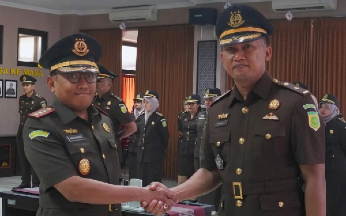Foto Kajari Sleman Dr Dinar Krispiaji SH MH (kiri) memberikan ucapan selamat dengan berjabat tangan kepada pejabat baru Kepala Seksi Tindak Pidana Khusus (Kasi Pidsus), Ferry Dewantoro Nugroho SH MH, usai prosesi pelantikan di Gedung Kejari Sleman. (Foto: Kejari Sleman for Ketik.com)