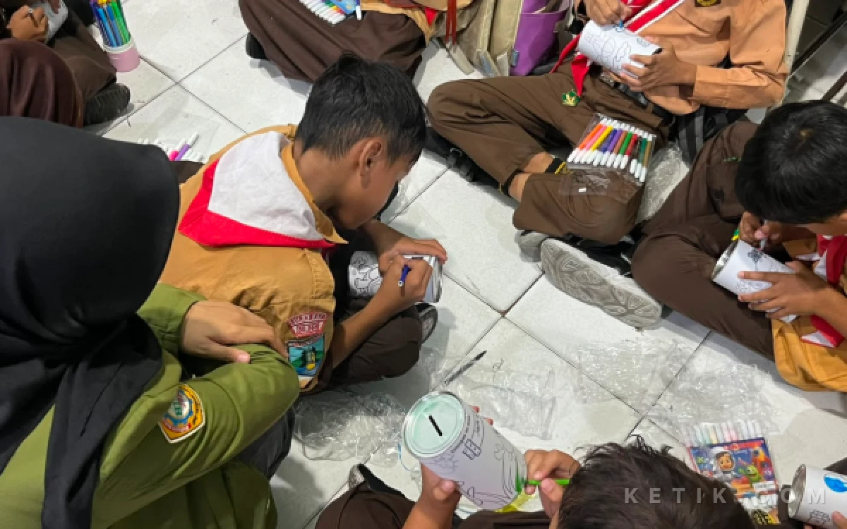Foto Mahasiswa KKN UPN "Veteran" Jawa Timur Kelompok 20 mendampingi siswa kelas III SDN 1 Wonokromo saat melukis celengan sebagai rangkaian kegiatan edukasi menabung sejak dini di ruang kelas, Surabaya, Jumat (7/8/2025). (Foto: Ismy Dahlia Handayani/Ketik Media)