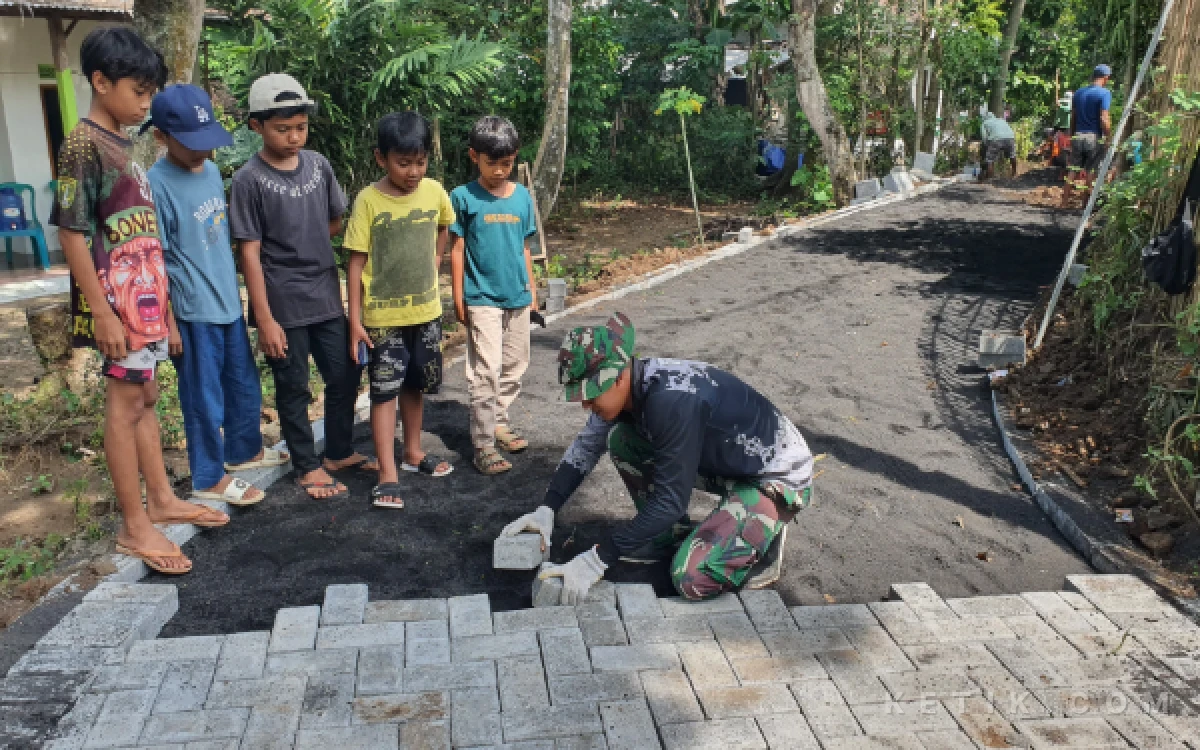 Thumbnail Berita - TMMD Ke-128 Kodim 0820 Probolinggo Curi Perhatian Anak-Anak, Aksi TNI Pasang Paving Jadi Tontonan